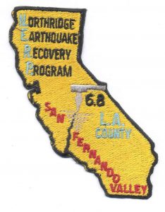 Photo of uniform patch. Shape of California, reads Northridge Earthquake Recovery Program, San Fernando Valley, 6.8, L.A. County