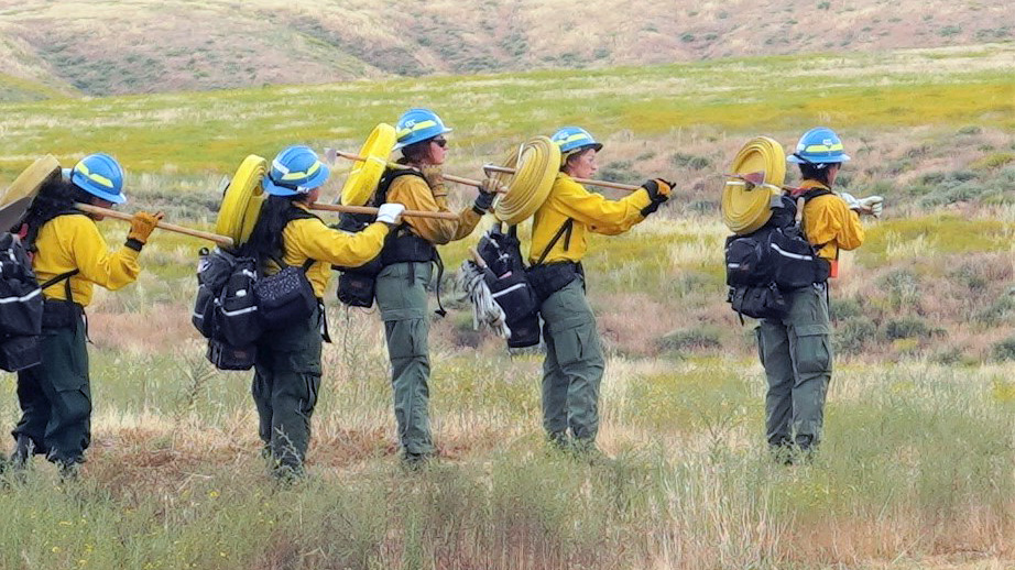 Corpsmembers from the Inland 5 all-female BLM fire crew prepare to lay hose.