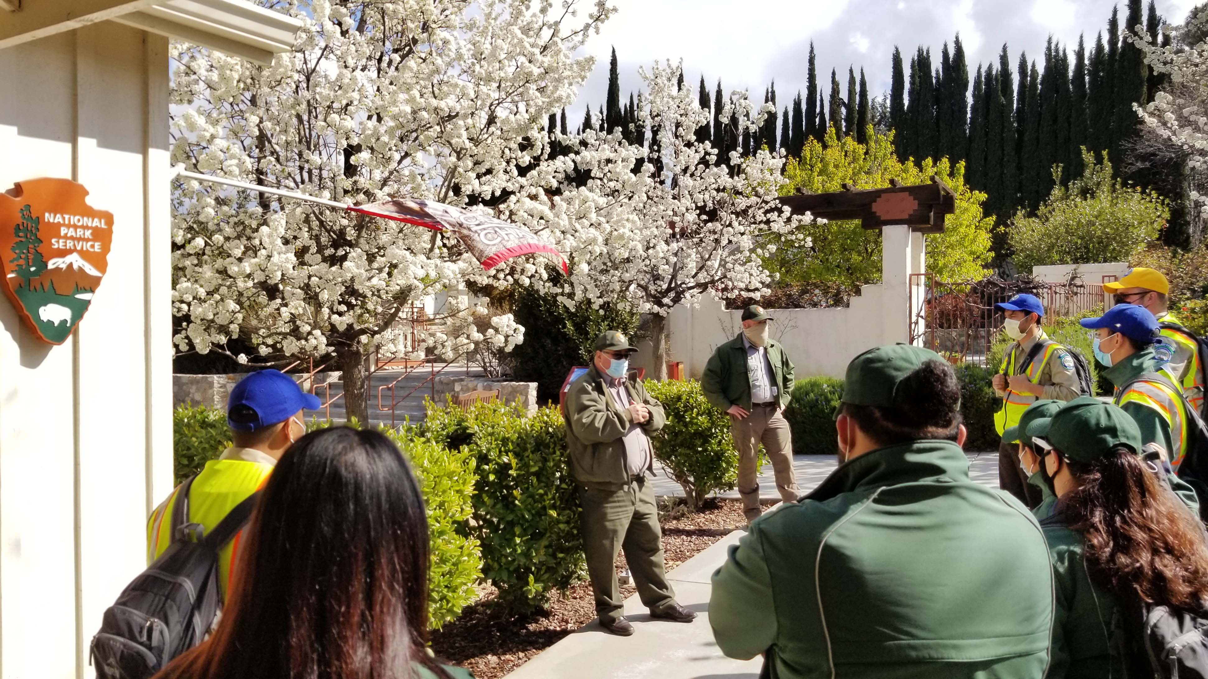 corpsmembers standing in semi circle listening to national parks docents speak