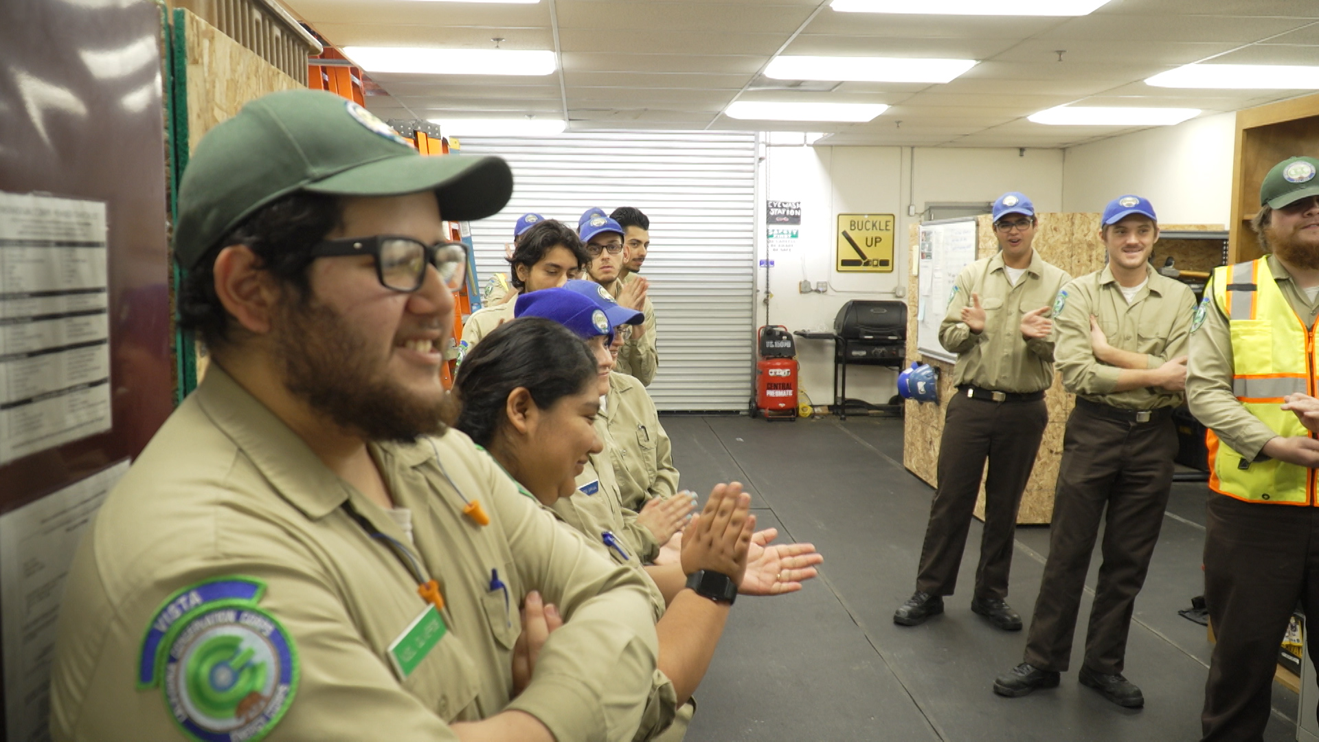 corpsmembers applauding during afternoon roll call in supply room