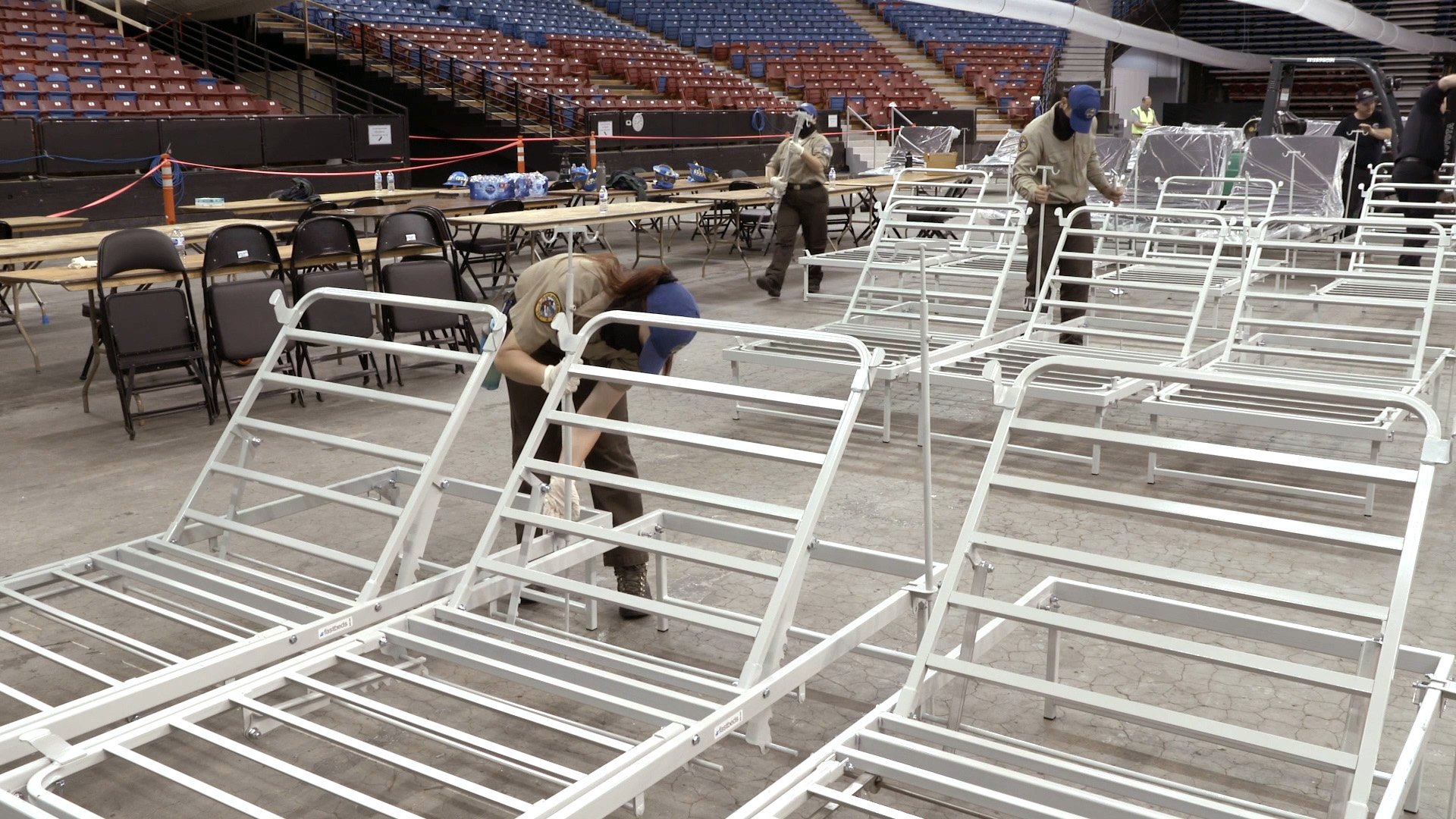 corpsmembers set up hospital beds in arena