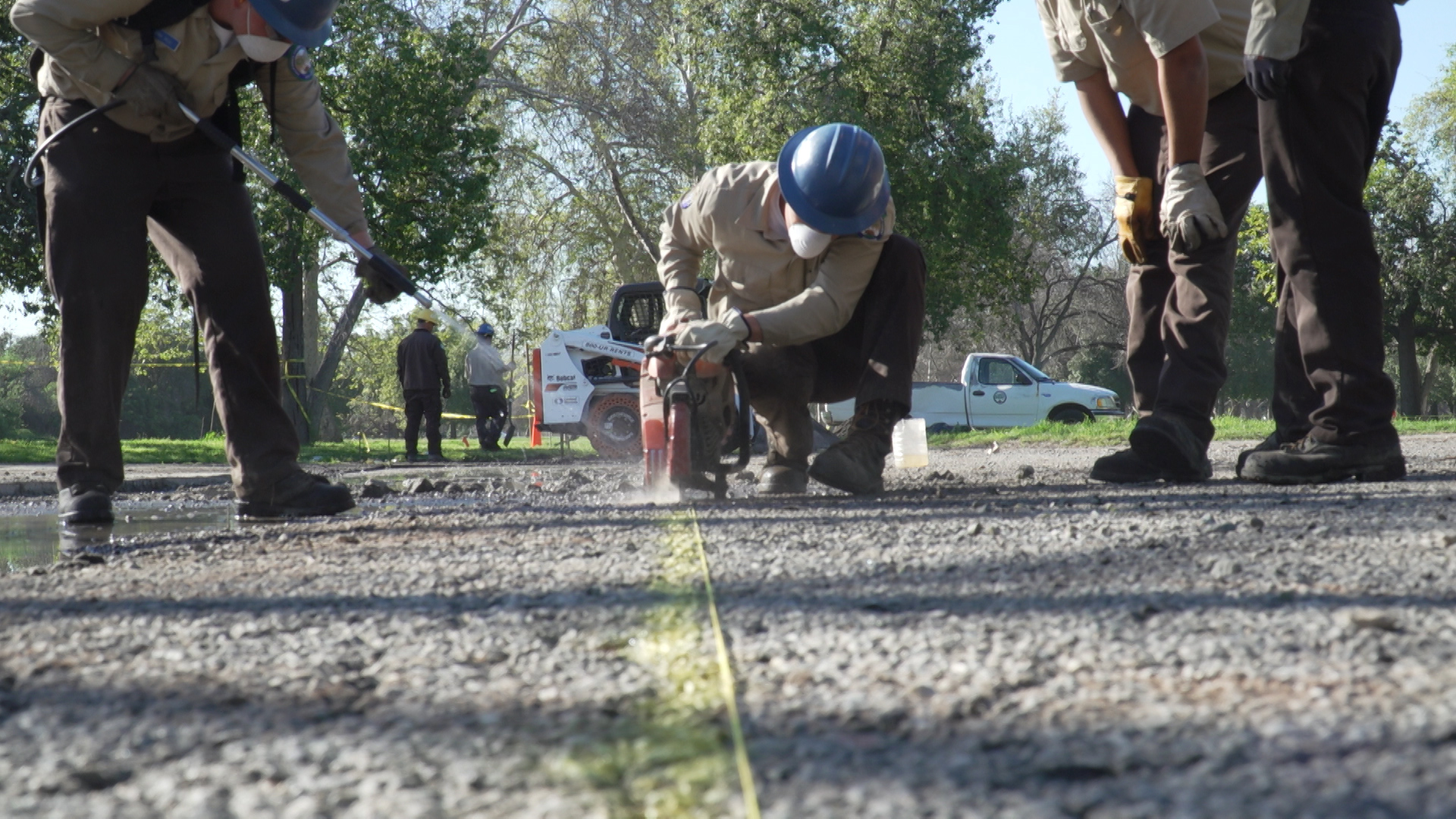 male corpsmember using concrete saw on asphalt parking lot