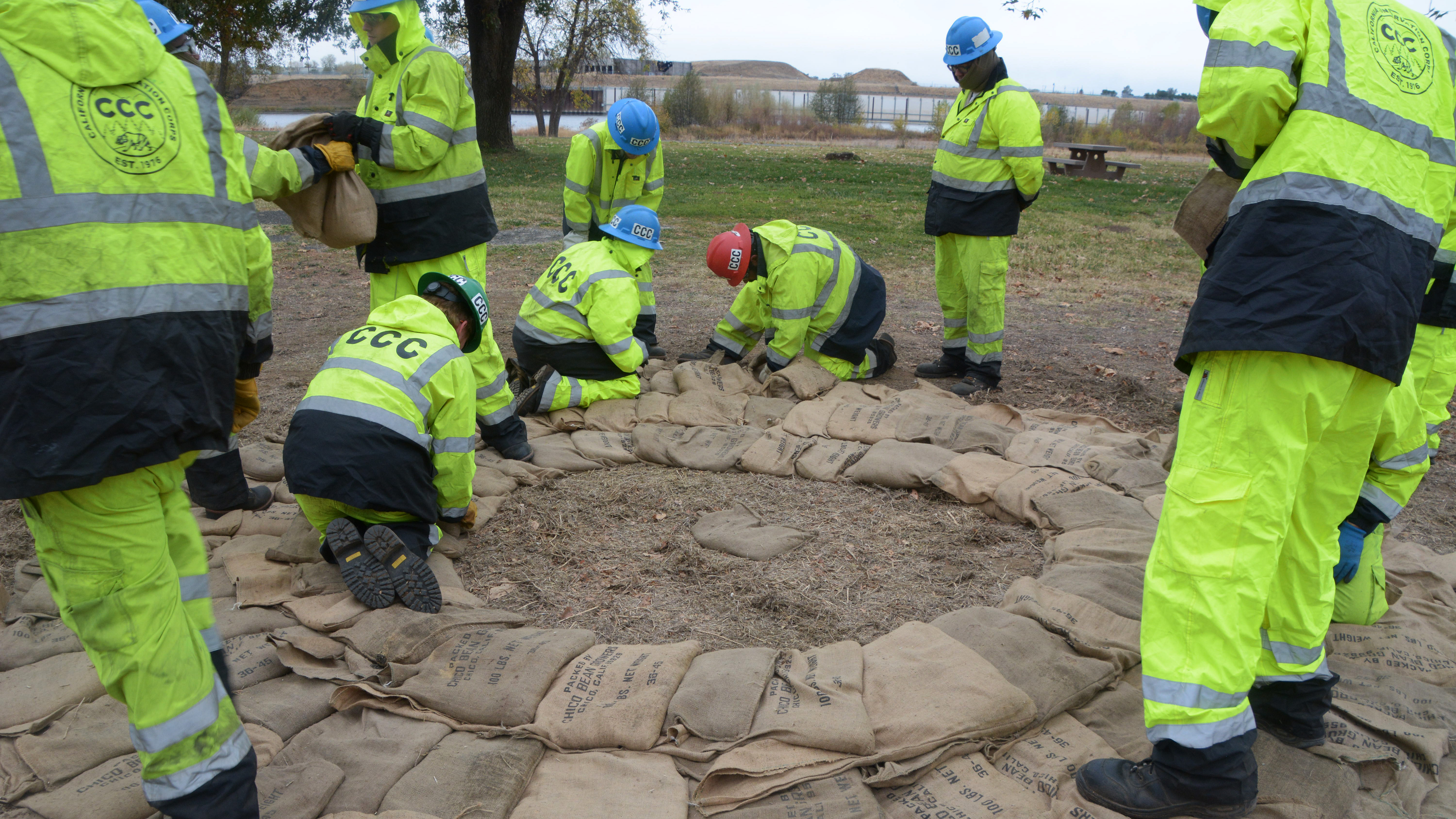 corpsmembers use sandbags to build a ring during flood training