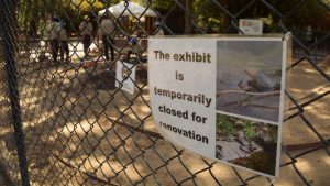 sign reading the habitat is closed for renovations with corpsmembers working in the background