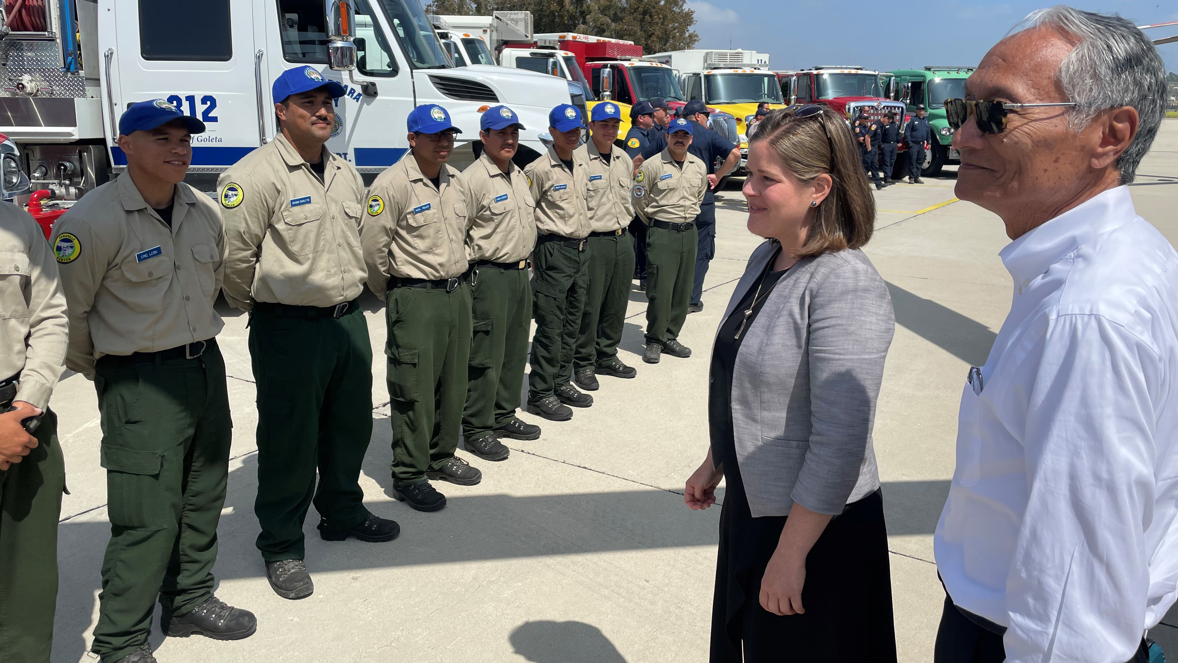 corpsmembers standing at attention, man and woman talking to them