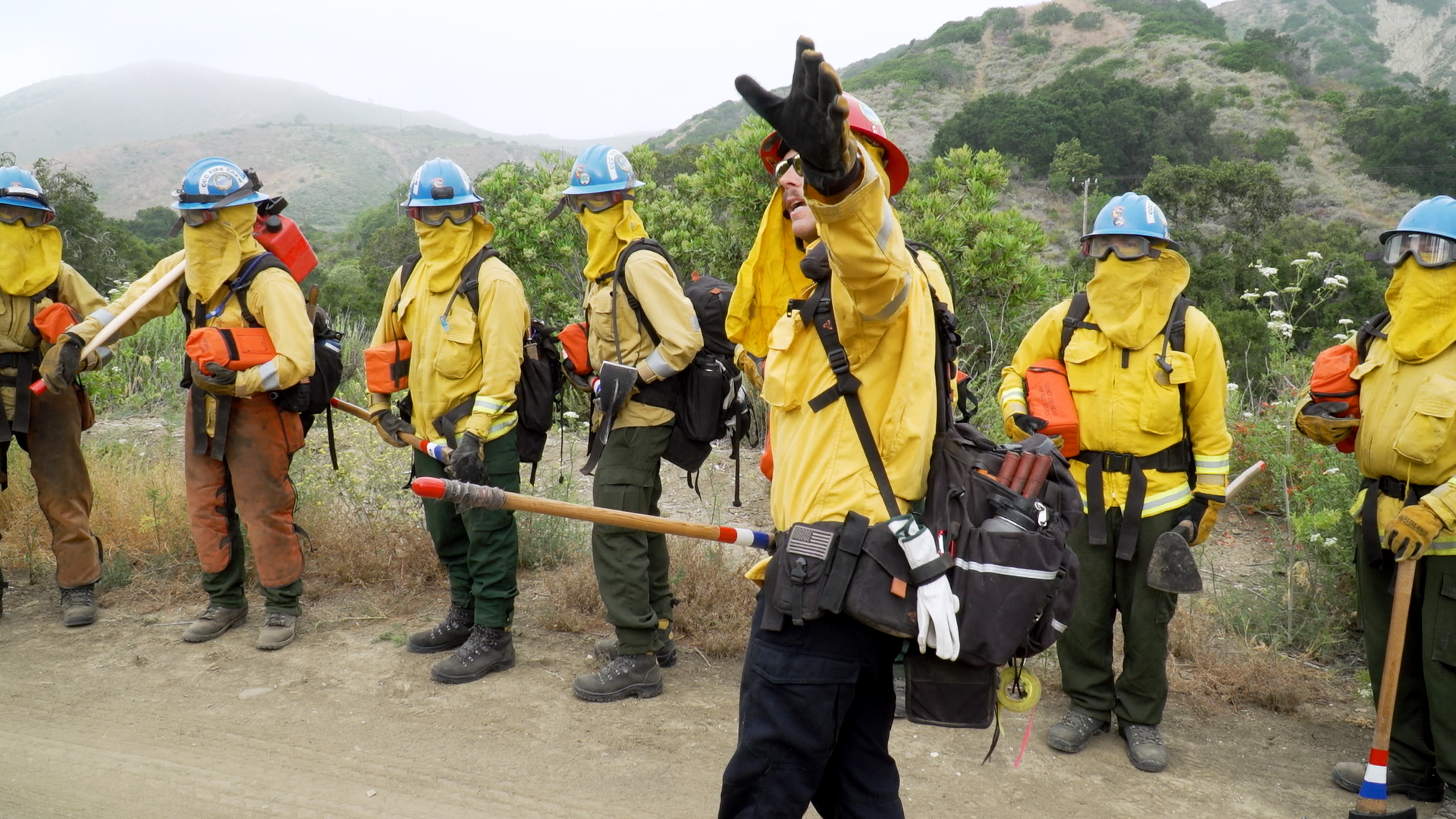 corpsmembers in full firefighting nomex get final instructions from their captain