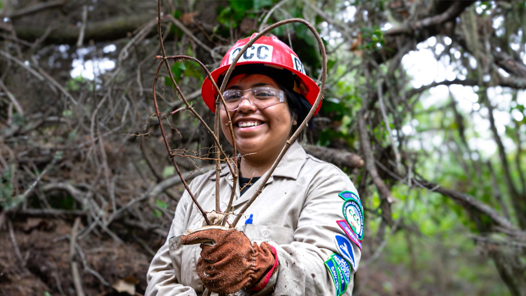 female corpsmember holding up english ivy vines