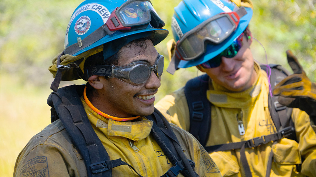 corpsmembers in fire gear smile during training