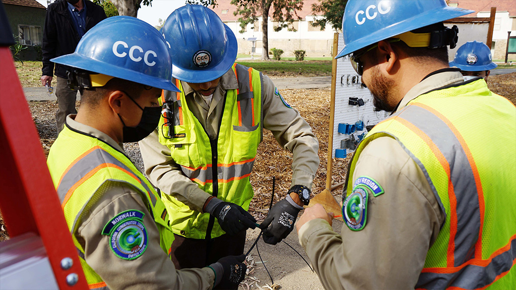 corpsmembers standing holding electrical cables