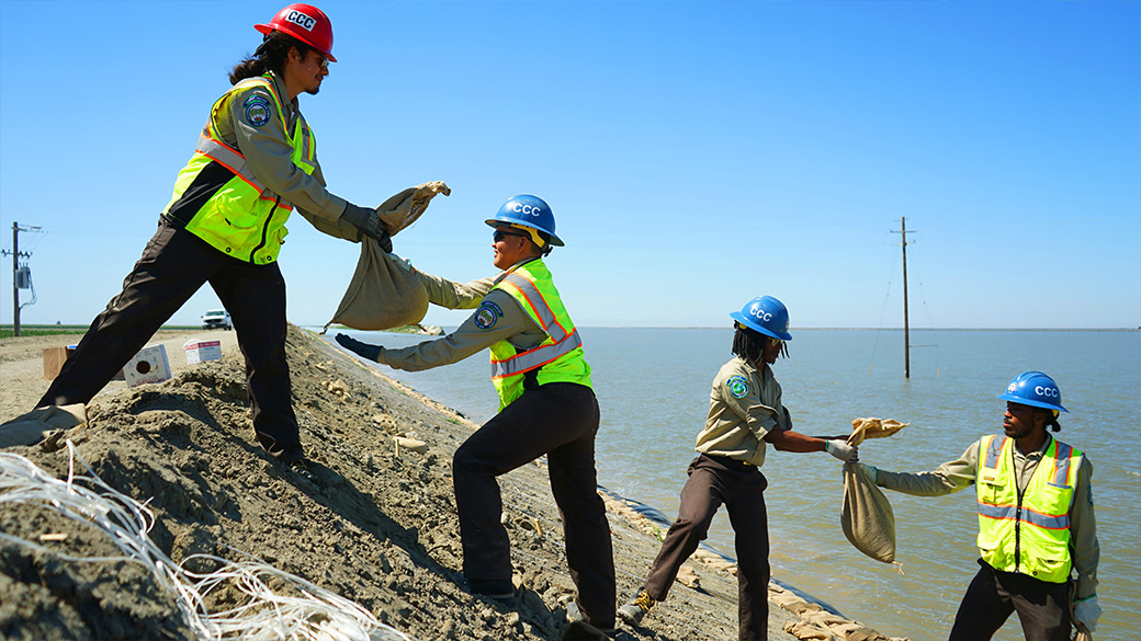 corpsmembers chaining sand bags on levee