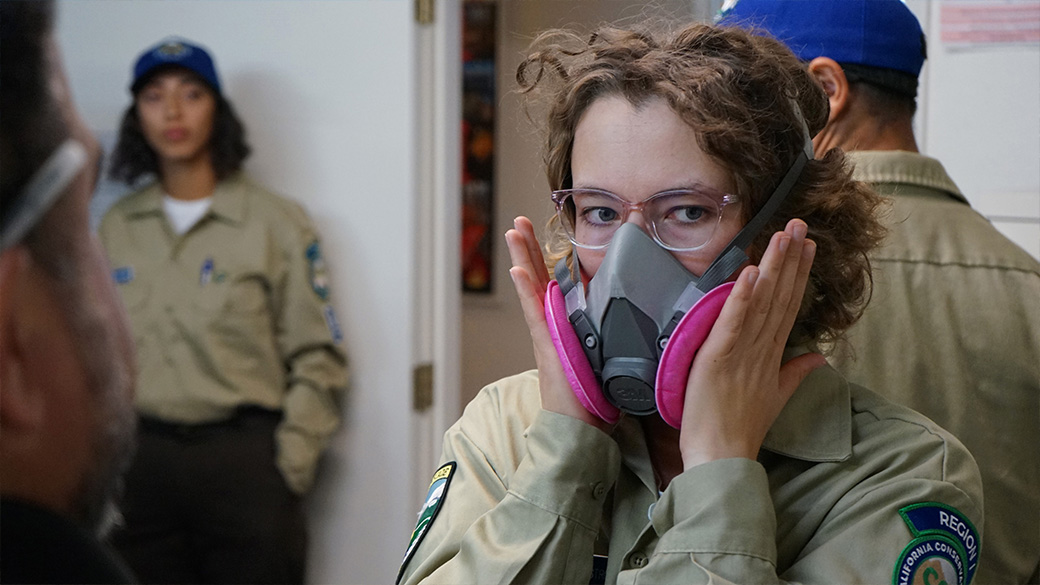corpsmember pressing respirator to their face