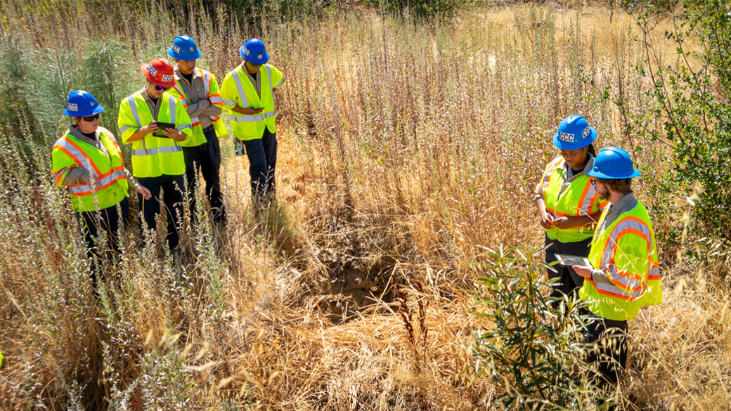 corpsmembers standing in field with tablets