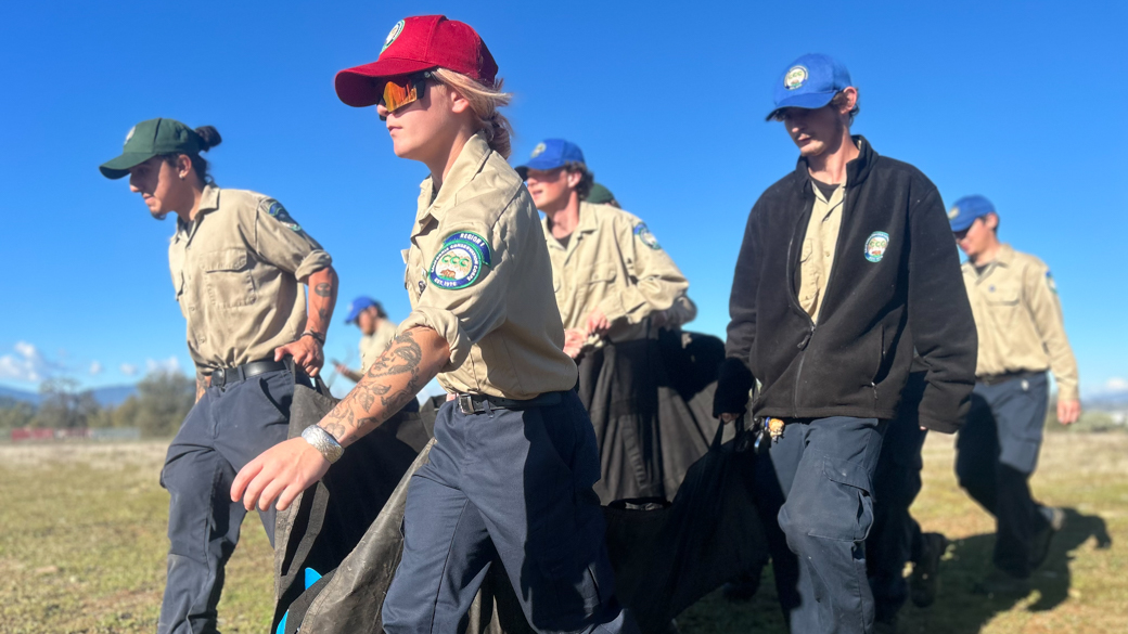 Corpsmembers transport a member of their crew in a gurney.