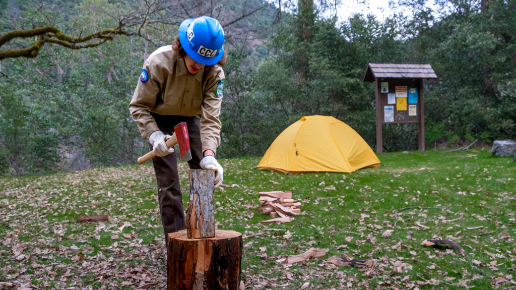 corpsmember prepares to use axe to cut wood