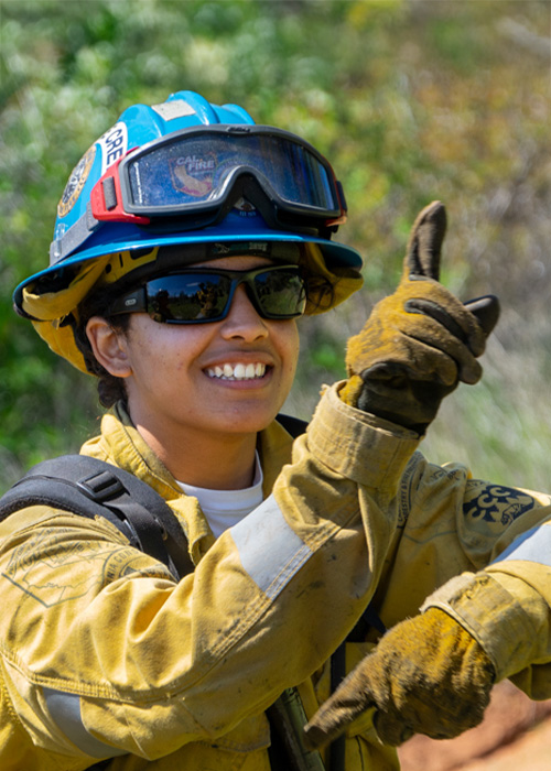 SideImage_Placer_500x700 Wildland firefighting Corpsmember pointing and smiling.
