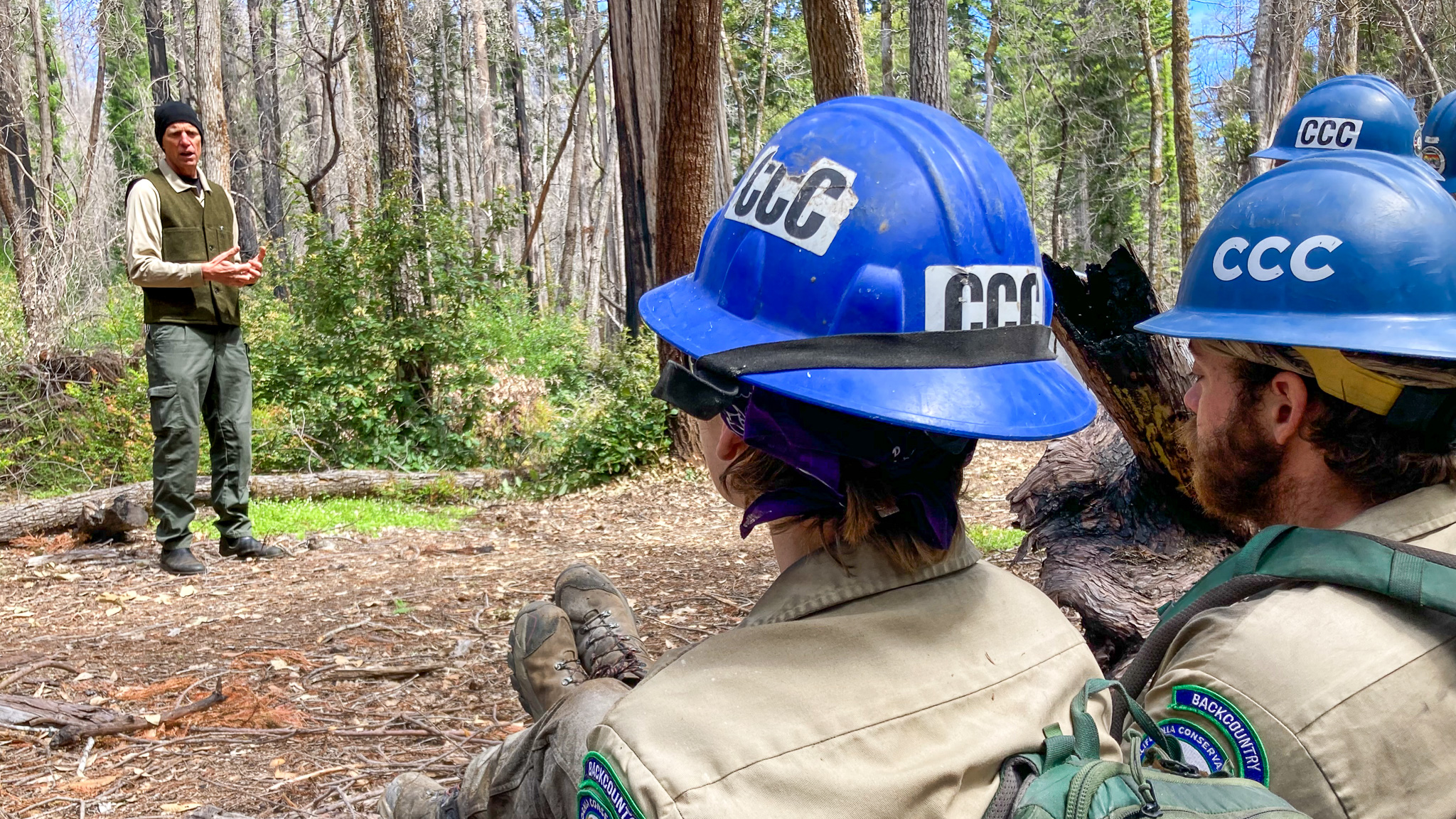 A CCC Backcountry Corpsmember listens and learns from a project sponsor while in the wilderness.