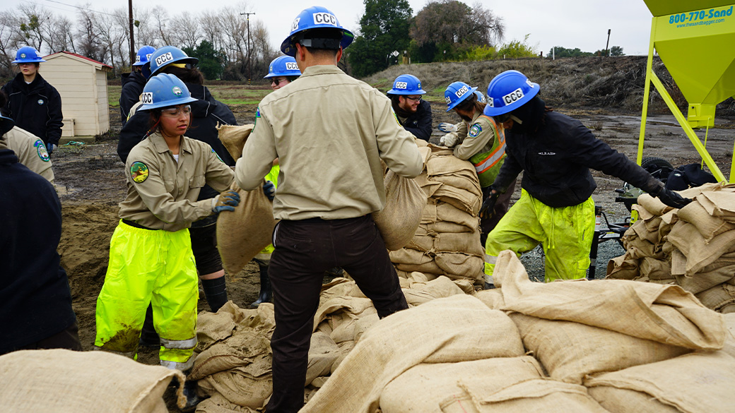 Corpsmembers passing along sandbags.