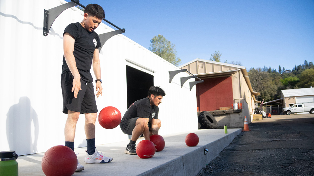 Corpsmembers exercising using weighted medicine balls.