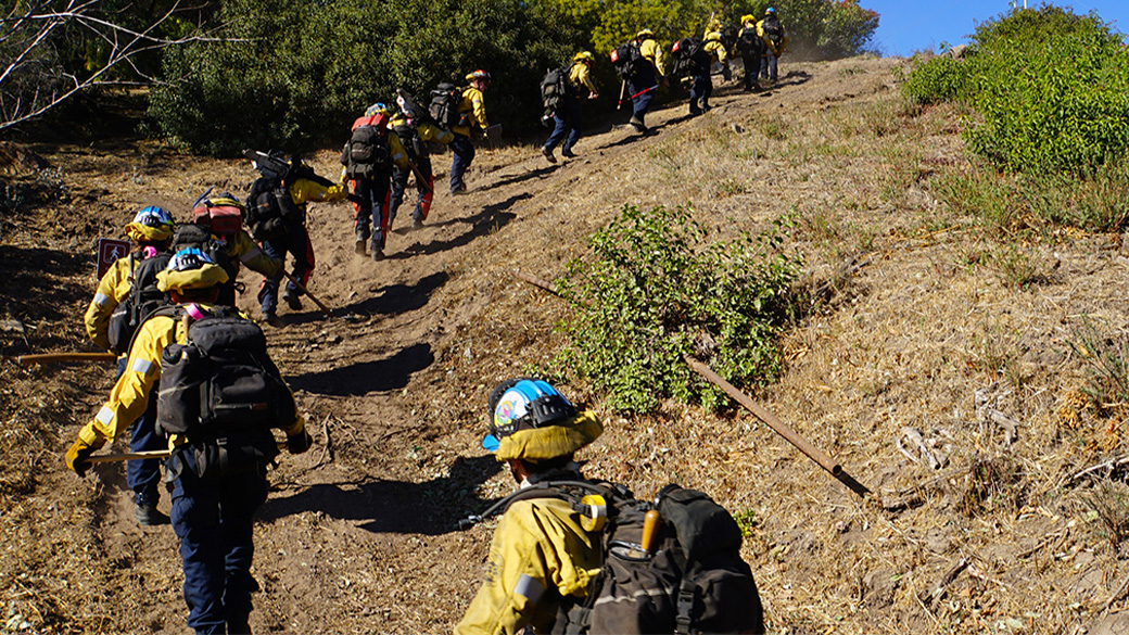 Wildland firefighting Corpsmembers hiking to location.
