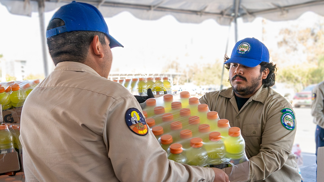 Emergency_SanDiego_Camp_EatonReefer_011325_1040x585 male corpsmembers chain gatorade pallet at a supply station.