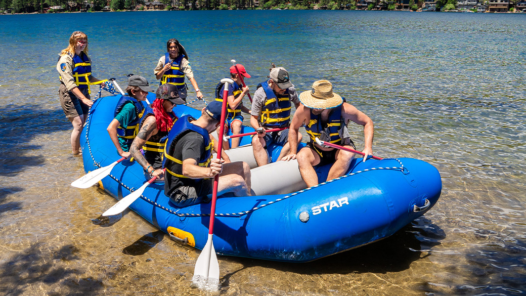 2 Corpsmembers giving instructions, visitors on raft.