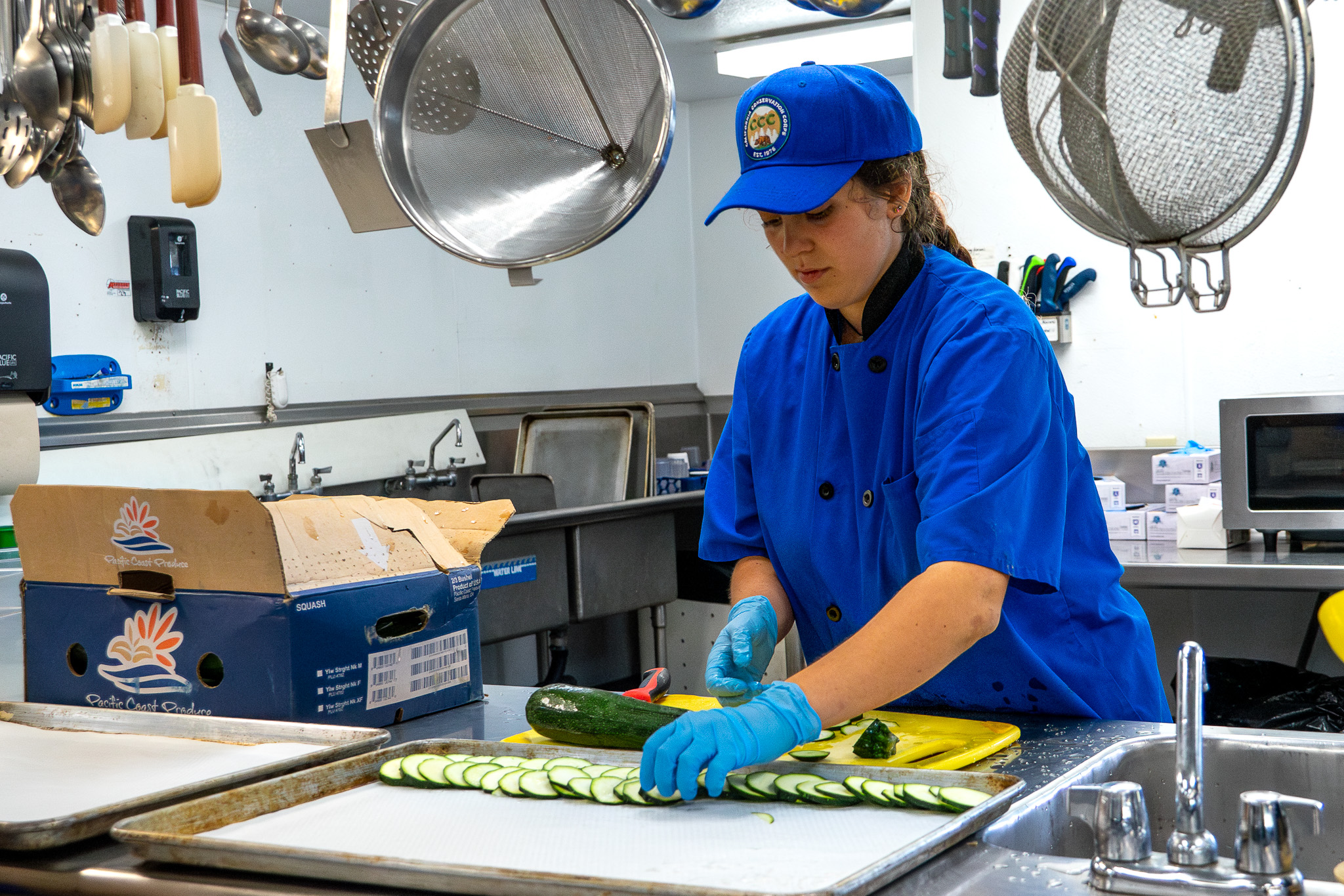 Culinary Corpsmember slicing zucchini