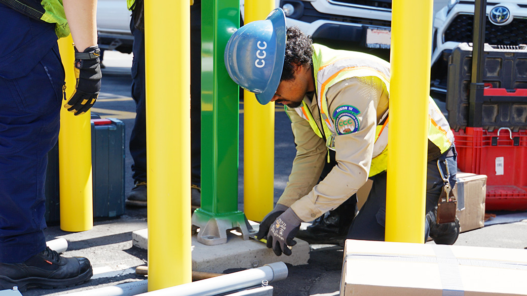corpsmember on ground using a tape measure to check pedestal placement