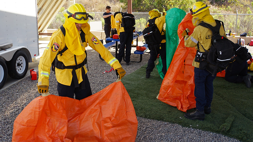 SanDiego_ShelterPractice_SDUHires_062525_1040x585 male in full firefighting gear deploys a practice fire shelter