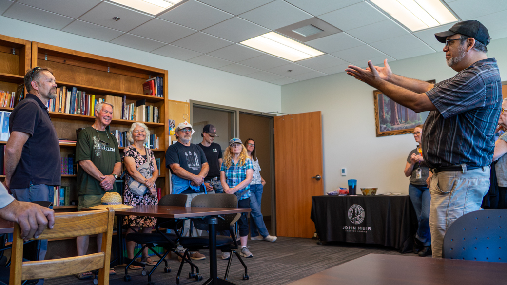 A teacher from the John Muir Charter School welcomes a tour group into the classroom at the Mendocino Center