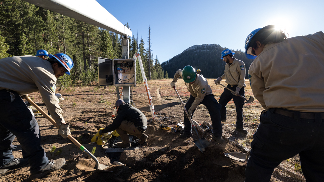 CCC Corpsmembers cover the base of the Hinge Fold Tilt-Pole with soil.