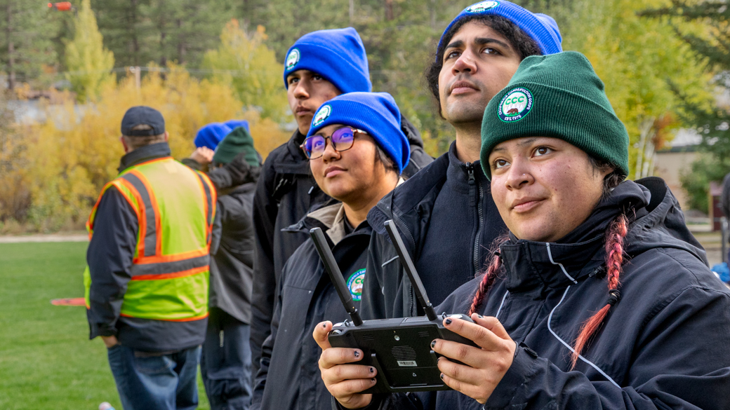 A CCC Corpsmember holds the drone controls while her crew keeps their eyes on the sky.