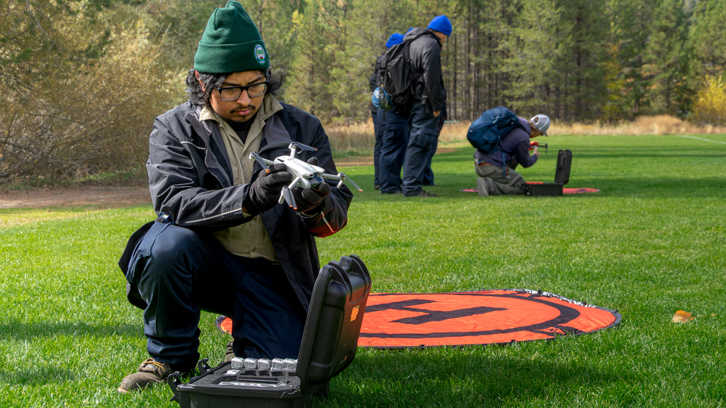 CCC Corpsmembers prepare to launch dones in a park.