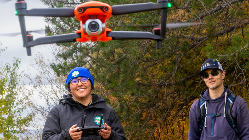 Under the supervision of UC Davis staff, a CCC Corpsmember pilots a drone. 