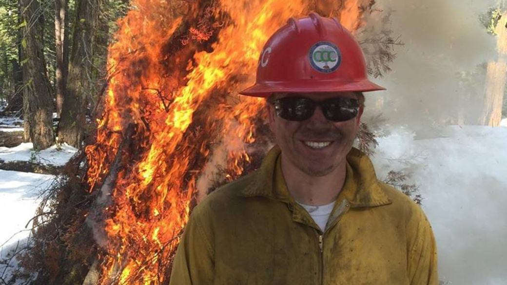 Crew lead Jett Reeves smiles as his crew burns piles to reduce fuel for wildfires.