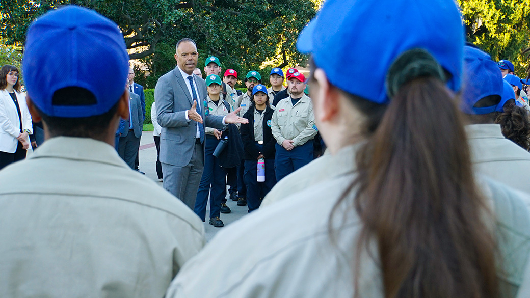 Director JP Patton speaks with Corpsmembers who form a semi-circle around to listen