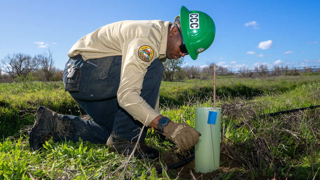 CCC Corpsmember, Michael Cherry III, checks irrigation lines in the Haller Muller Restoration Area. 
