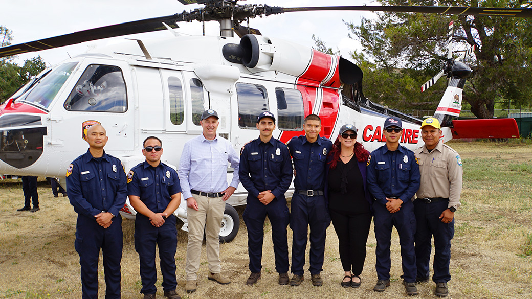 cal fire firefighters and ccc staff pose in front of a helicopter