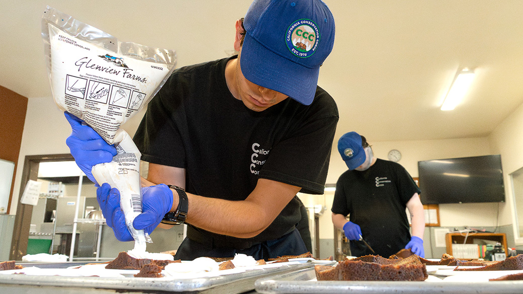 culinary corpsmember squeezing icing on to cupcake