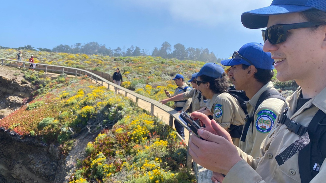 Corpsmembers looking toward the ocean from a clifftop trail.